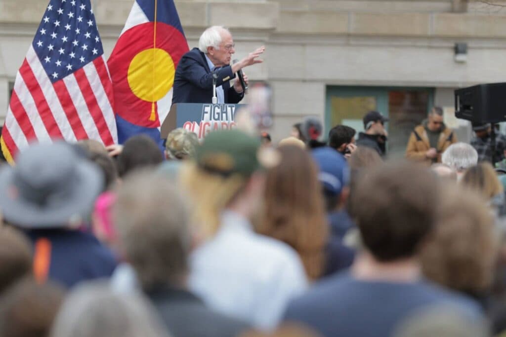 Bernie Sanders speaks at a podium reading "Fight Oligarchy."