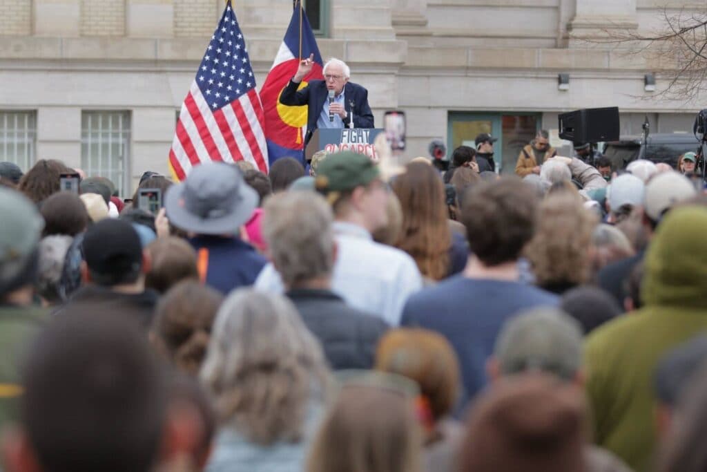 Bernie Sanders speaks at a podium reading "Fight Oligarchy."