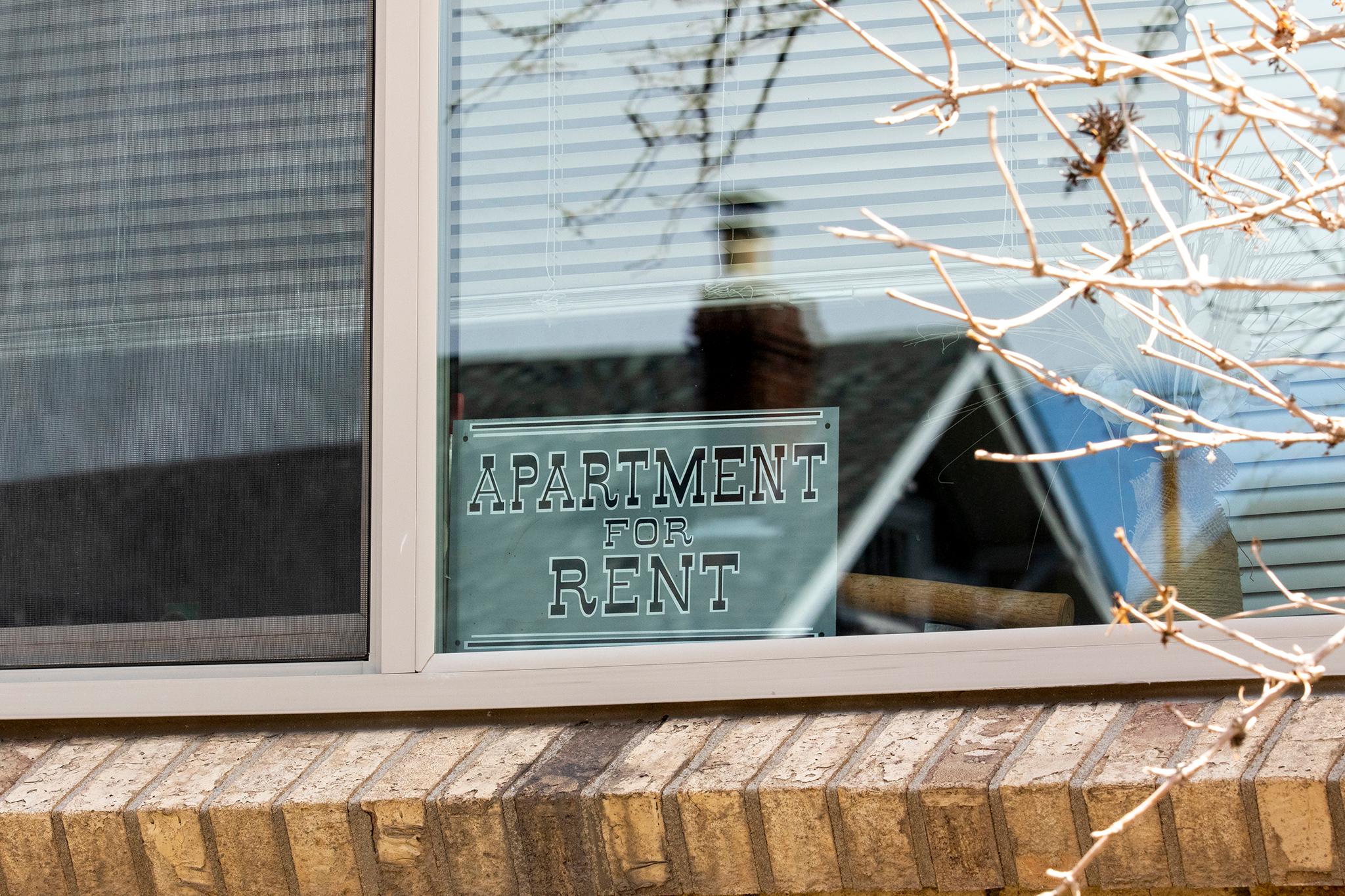 An "Apartment for Rent" sign in the window of a building in Denver