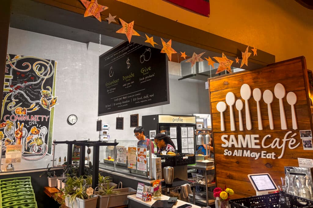 The front counter of SAME Cafe, with two volunteers behind the counter preparing food for the next day, Aug. 28, 2025.