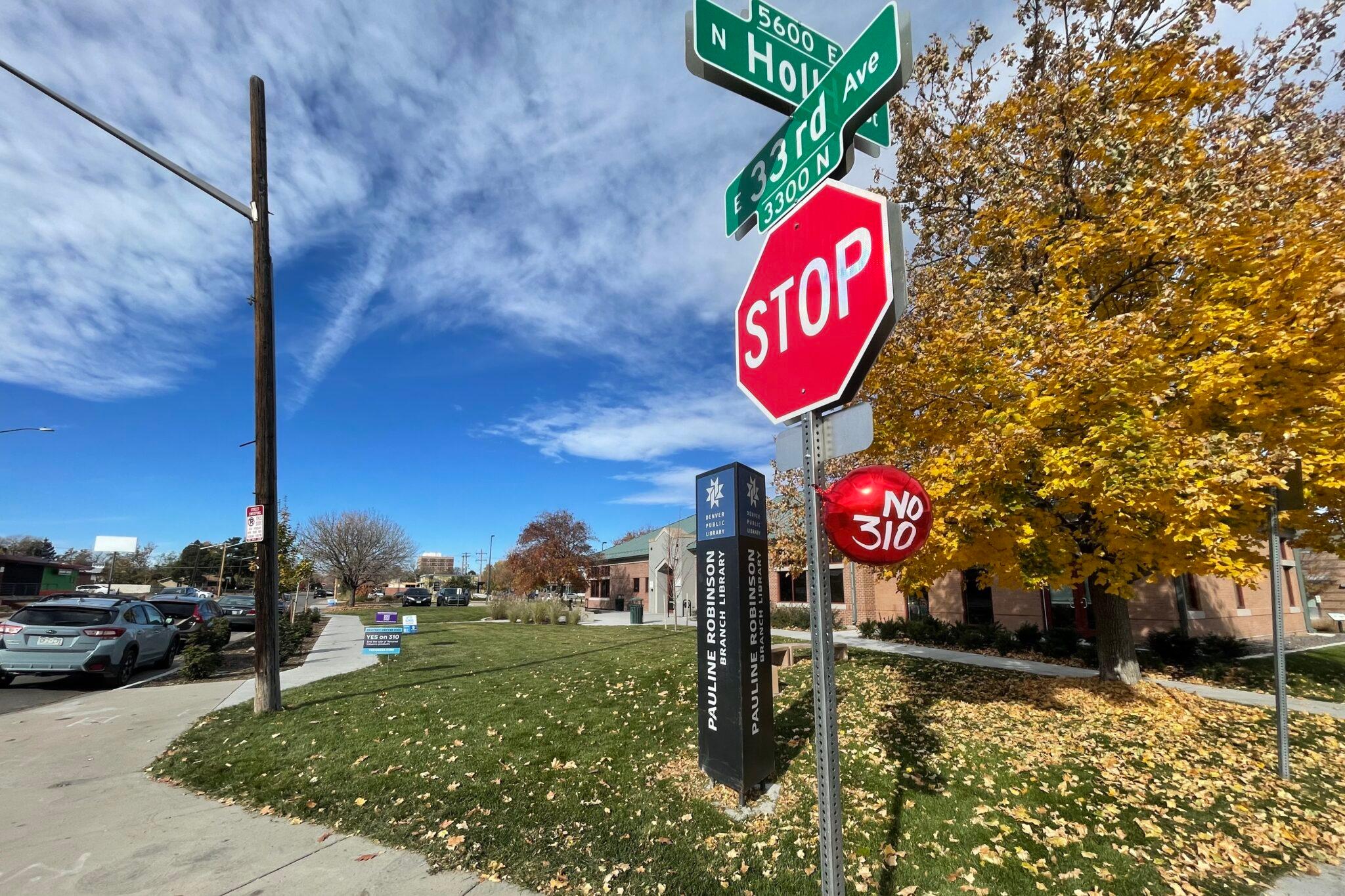 A red balloon with "No on 310" written in white lettering is tied under a stop sign.